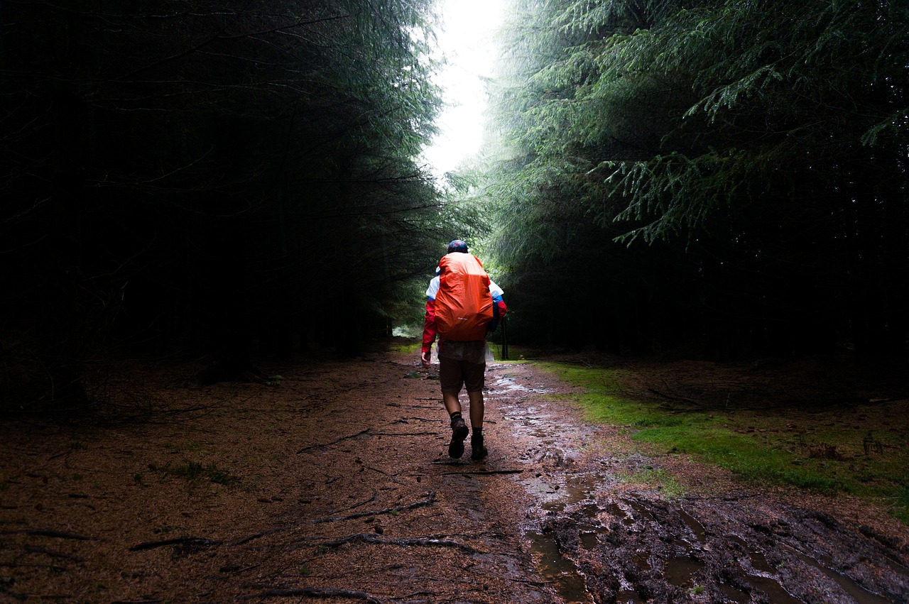 Mann wandert im Regen, Rucksack ist vor Wasser geschützt